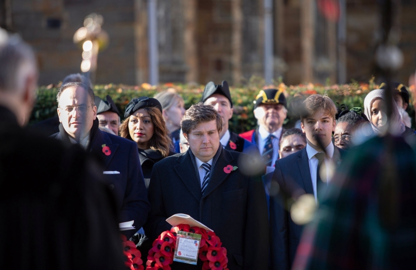 Andrew Lewer MP standing with his poppy wreath